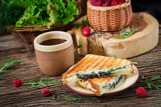 Panini sandwich with cheese and mustard leaves. Morning coffee. Village breakfast