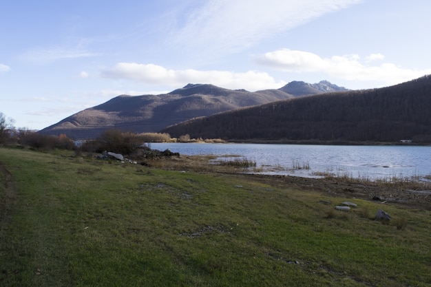 Panoramic shot of a grassy shore line with hills