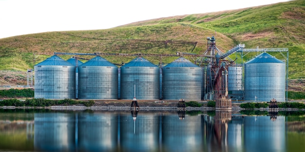 Free photo panoramic shot of industrial buildings on the shore of the lake reflected in the water