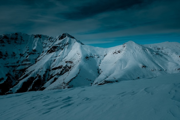 Free photo panoramic shot on top of a snow covered mountain under cloudy skies