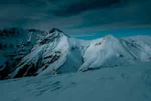 Free photo panoramic shot on top of a snow covered mountain under cloudy skies