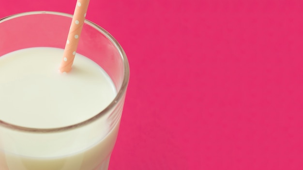 Free photo panoramic view of milk in the glass with drinking straw