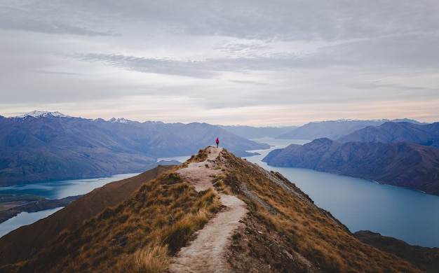 Free Photo panoramic view of the roys peak in new zealand with low mountains in the distance under cloudscape