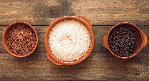 Panoramic view of three different organic rice bowls on wooden table