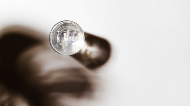 Free photo panoramic view of water glass with ice cubes on white backdrop