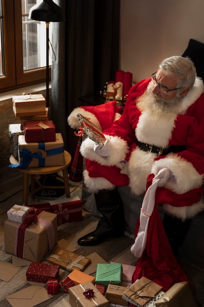 Papa noel preparing wrapped gifts for children