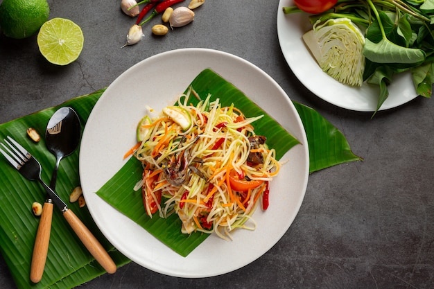 Papaya salad served with rice noodles and vegetable salad Decorated with Thai food ingredients.