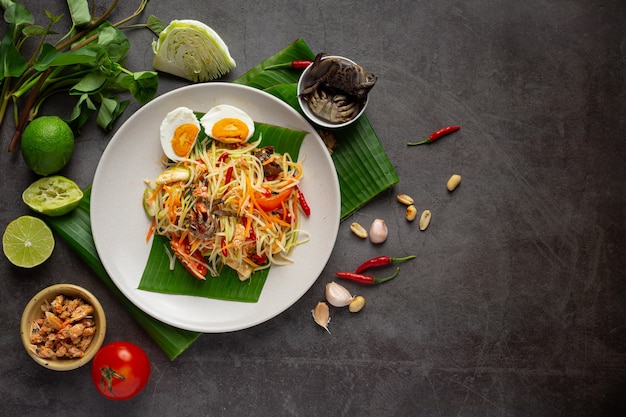 Papaya salad served with rice noodles and vegetable salad Decorated with Thai food ingredients.