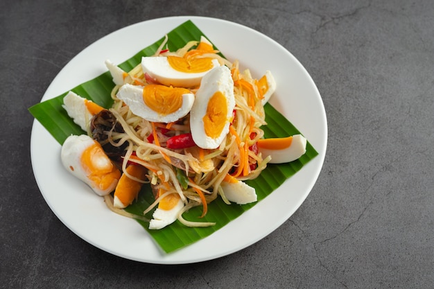 Papaya salad served with rice noodles and vegetable salad Decorated with Thai food ingredients.