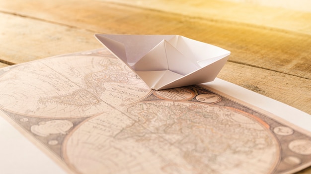 Paper boat with defocused old map