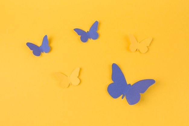 Free photo paper butterflies scattered on table