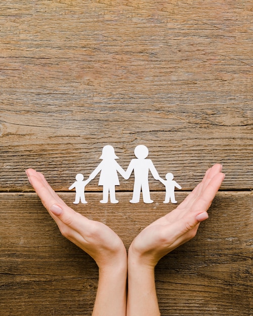 Paper family composition on wooden background with copy space