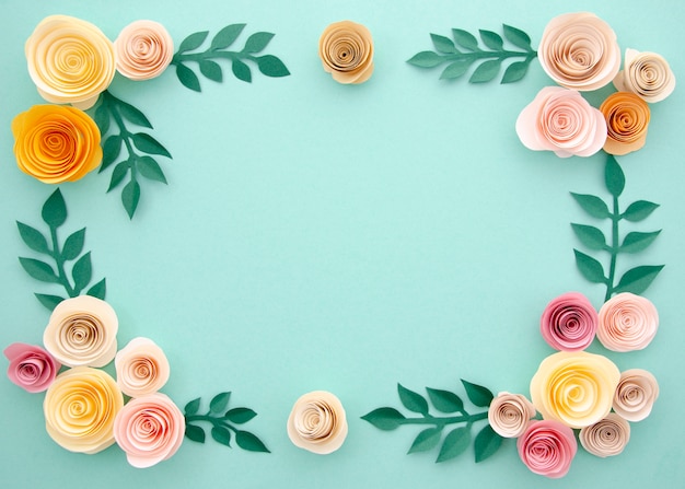 Paper flowers and leaves on blue background