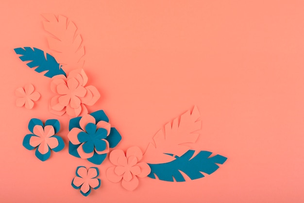 Free photo paper flowers and leaves on coral background