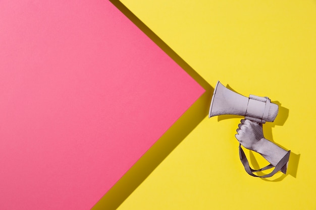 Paper hand holding megaphone