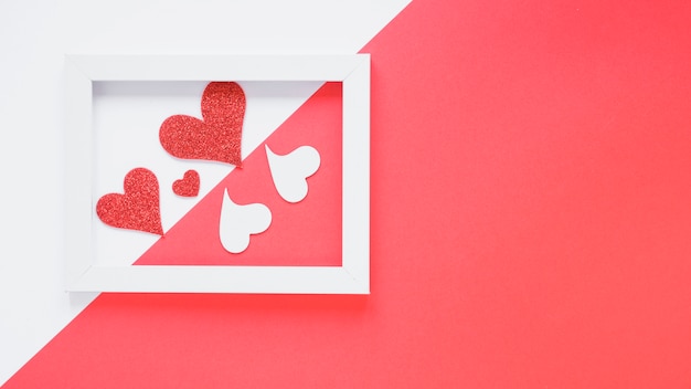 Free photo paper hearts between photo frame