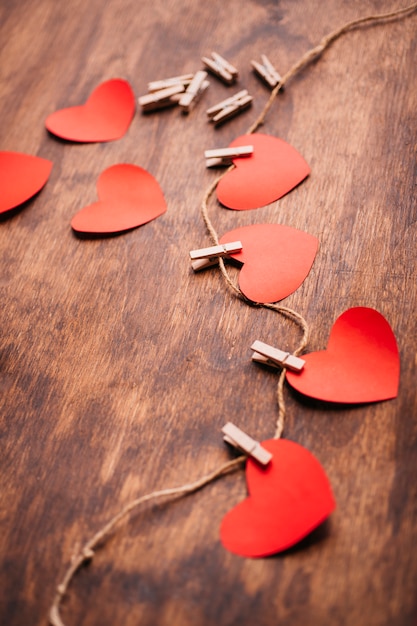 Paper hearts pinned to rope on table 