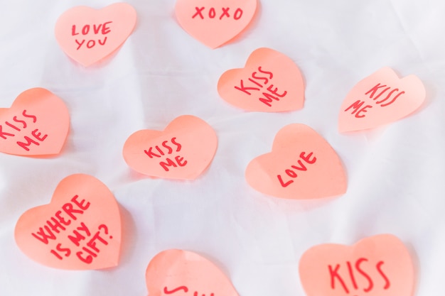 Paper hearts with inscriptions on table 