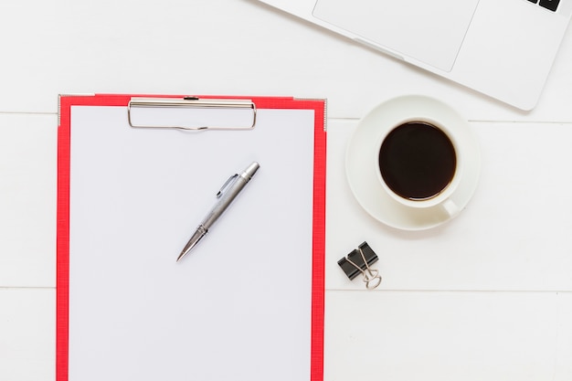 Paper holder next to cup of coffee 