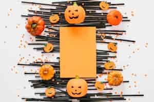 Free photo paper laid on plastic tubes with pumpkins around