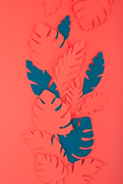 Free photo paper leaves on coral background