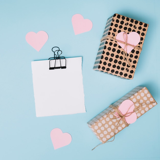 Paper near decorative hearts and present boxes 