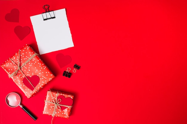 Paper near present boxes with ornament hearts, clips and magnifier