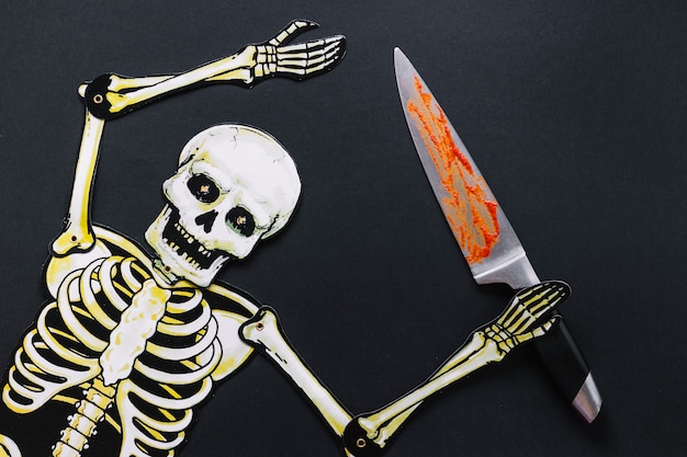 Free photo paper skeleton with bloody knife