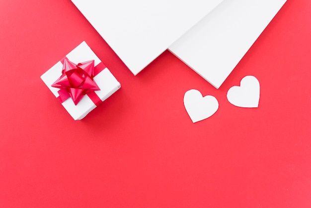 Papers near ornament hearts and present box 