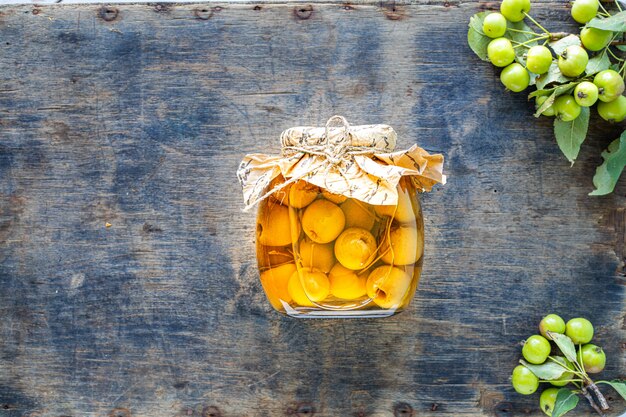 Paradise apples in sugar syrup on an old wooden surface