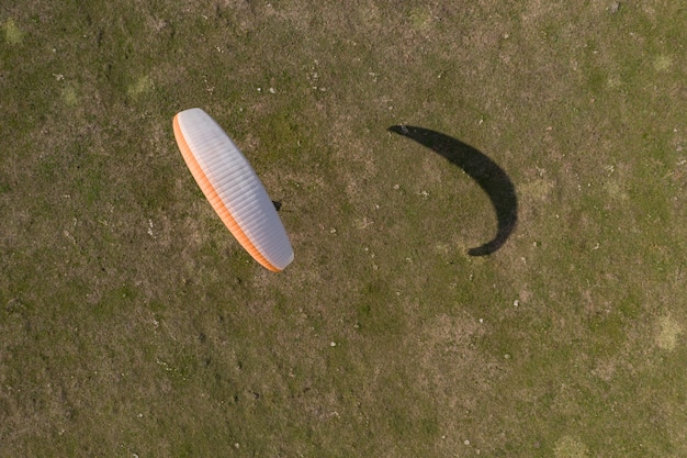 Free photo paraglider top view, he learns to fly on a plane field.