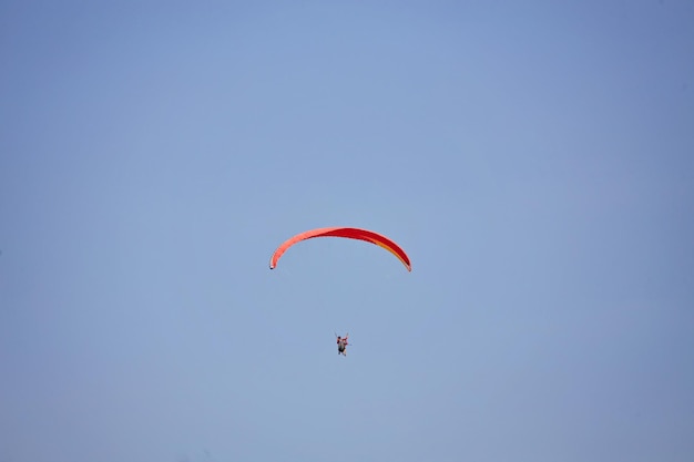 Paragliding in the sky Paraglider flying in bright sunny day Beautiful paraglider in flight on a turquise background