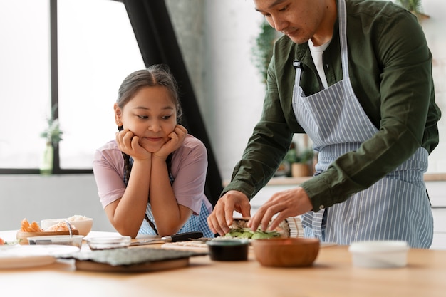 Parent teaching kid how to make sushi