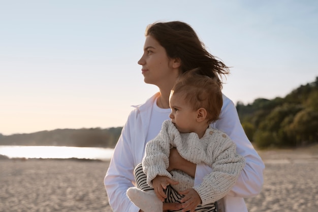 Free Photo parent with a baby on the beach at sunset