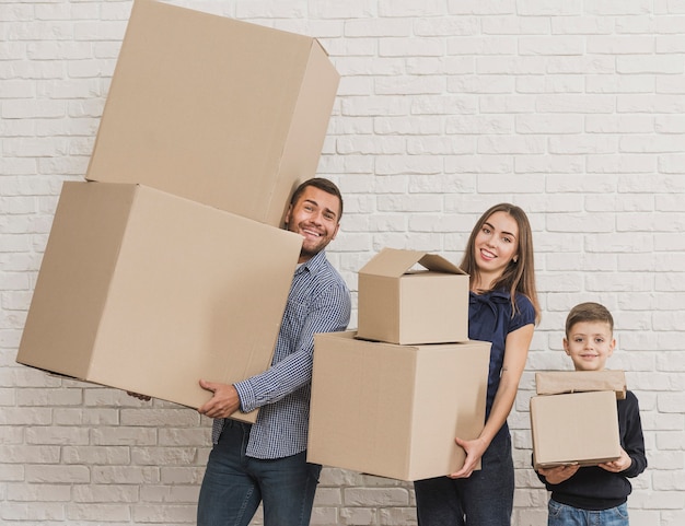 Parents and child holding cardboard boxes