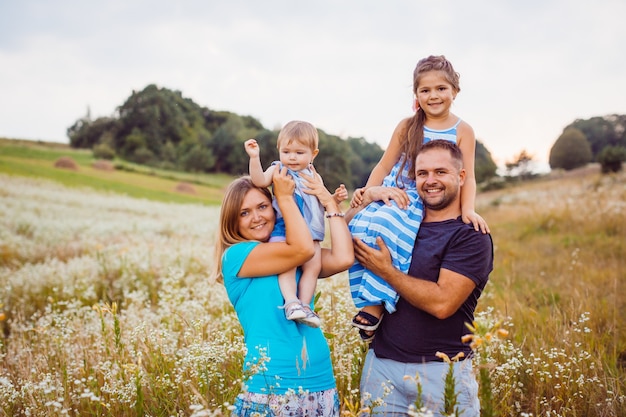 Parents hold their children on the shoulders standing on the field 