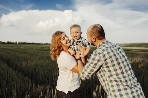 Free photo parents hold their little son and they have fun