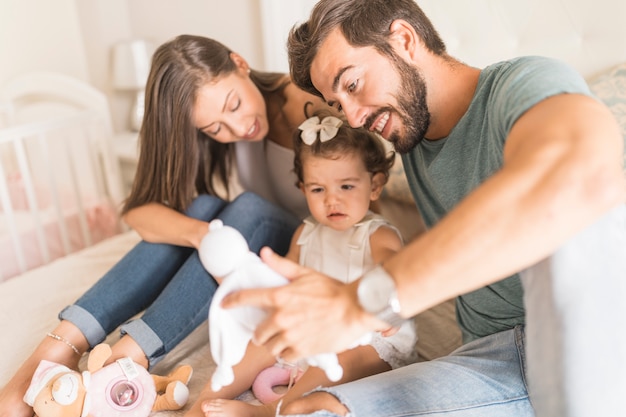 Parents offering toys to daughter