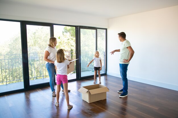 Parents and their children talking during removal in new house