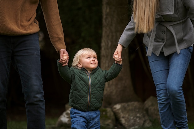 Parents walking with cute kid in park