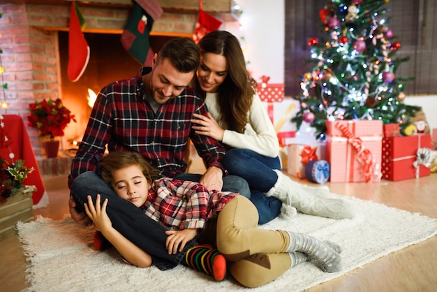 Parents with their little daughter sleeping in their living room