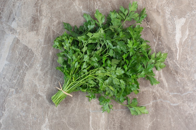 Parsley leaves tied up on marble.