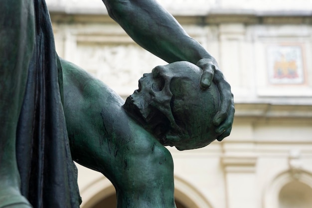 Free photo part of bronze sculpture of man with skull