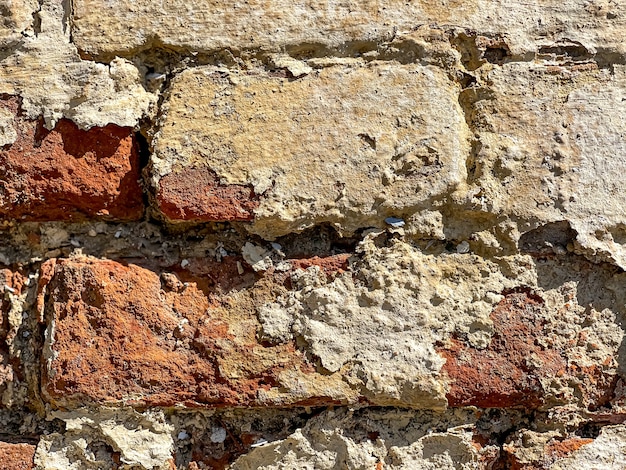 Part of an old brick wall with bricks close up.