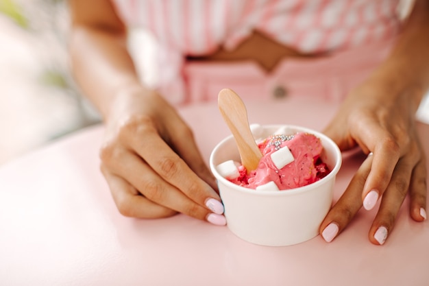 Partial view of woman eating ice cream. Selective focus of woman with sweet dessert.