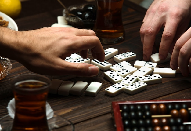 Party dominoes over a cup of hot tea