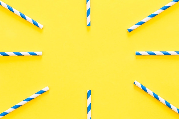 Free photo party drinking straws arranged into a circle on yellow background