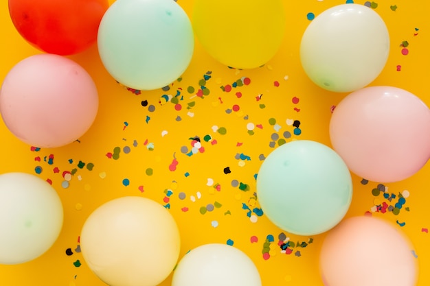 Party with confetti and balloons on yellow