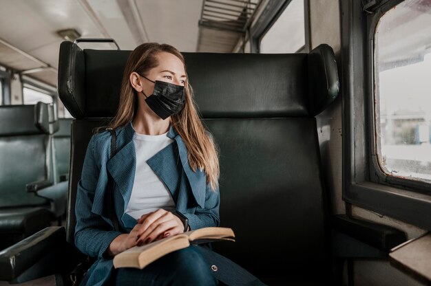 Passenger in the train wearing medical mask and looking out the window