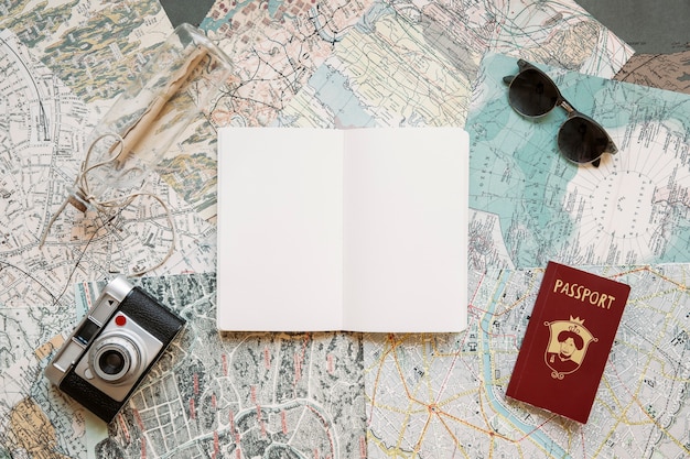 Passport with camera and notepad on maps